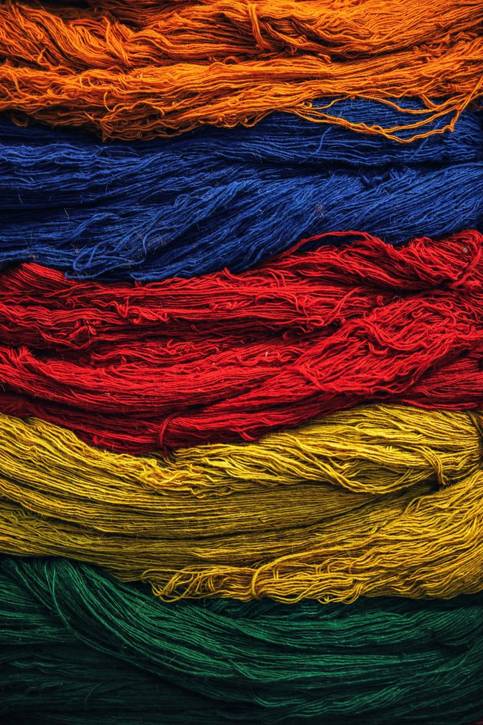 Services Bright multicolored textile threads arranged in layers, showcasing vivid colors and texture.