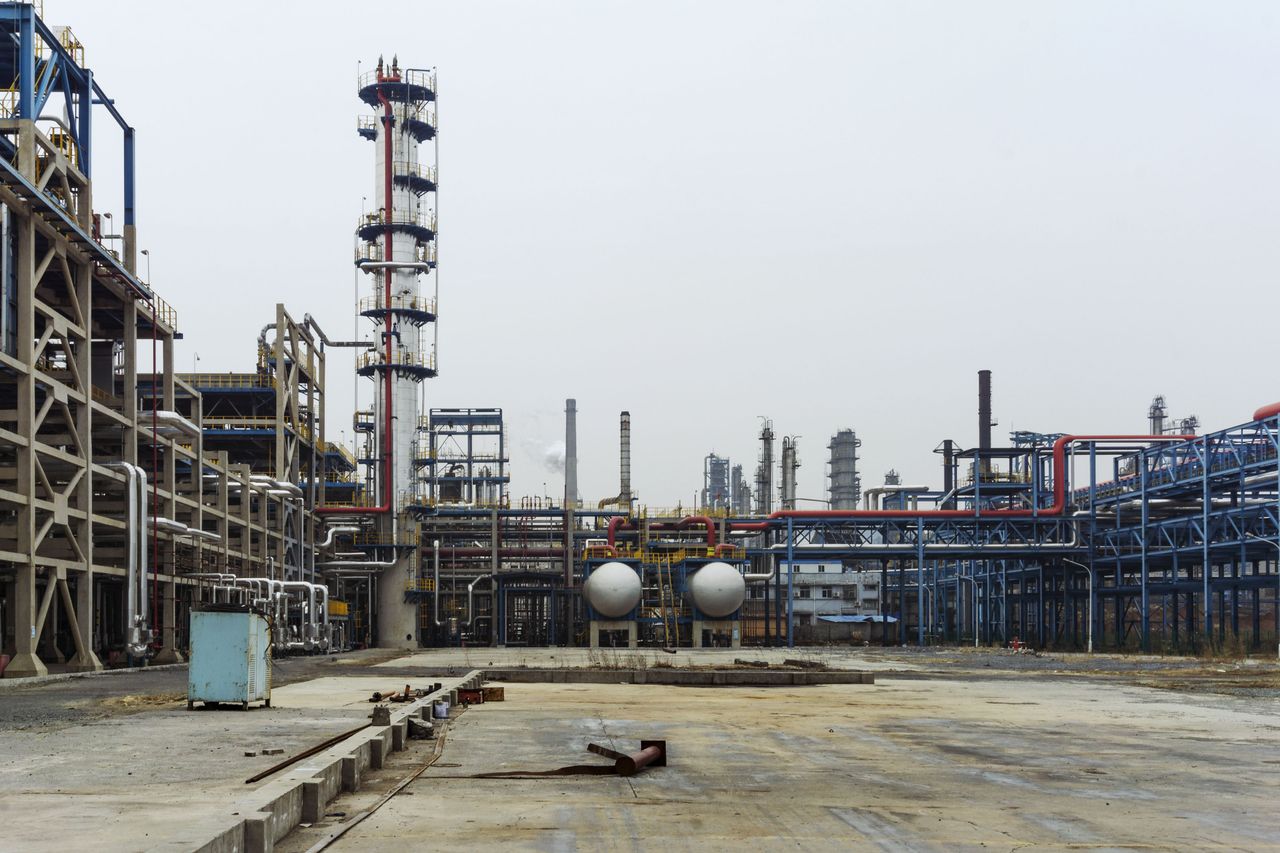 Services A detailed view of an industrial refinery featuring pipelines and large steel structures.