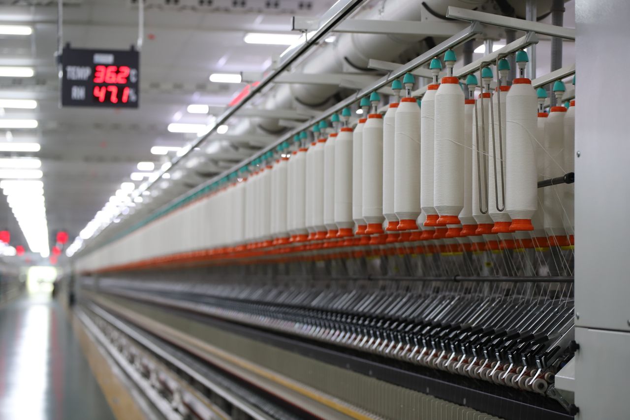 Home High-tech textile machinery with yarn spools in an Indian factory, demonstrating efficiency.